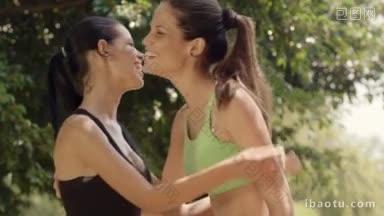 画像两个快乐的年轻女子见面和微笑后，锻炼在城市公园慢镜头